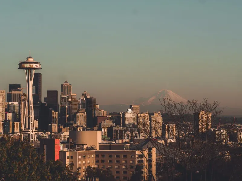 The Seattle skyline at golden hour with the Space Needle and Mount Rainier behind it