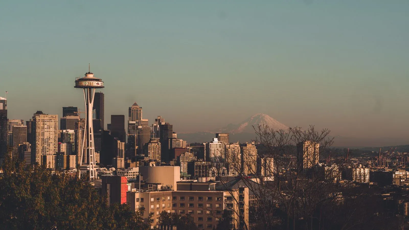 The Seattle skyline at golden hour with the Space Needle and Mount Rainier behind it